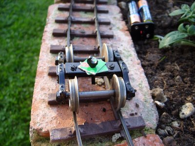photo of the bogies on track with a LEGO spanner in the bolt hole.